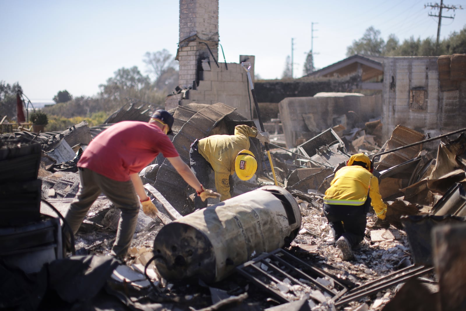 Todd Howard, left, sifts through the remains of his parents' fire-ravaged property with the help of firefighters after the Mountain Fire swept through, Thursday, Nov. 7, 2024, in Camarillo, Calif. (AP Photo/Ethan Swope)