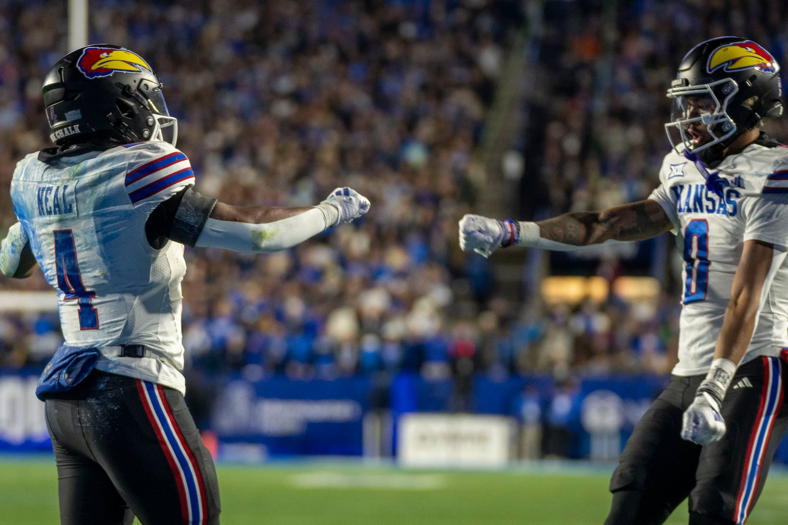 Kansas running back Devin Neal (4) celebrates his touchdown with Kansas wide receiver Quentin Skinner (0) during then first half of an NCAA college football game against BYU, Saturday, Nov. 16, 2024, in Provo. (AP Photo/Rick Egan)