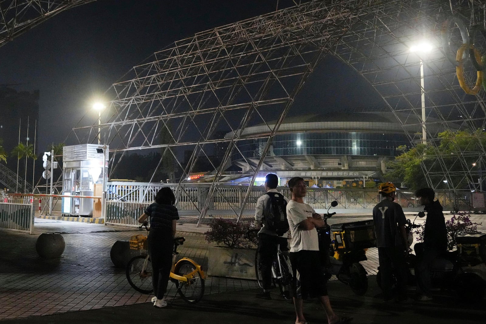 People gather near a sports center after a man rammed a car into people exercising at the center in Zhuhai, China Monday, Nov. 11, 2024. (Kyodo News via AP)