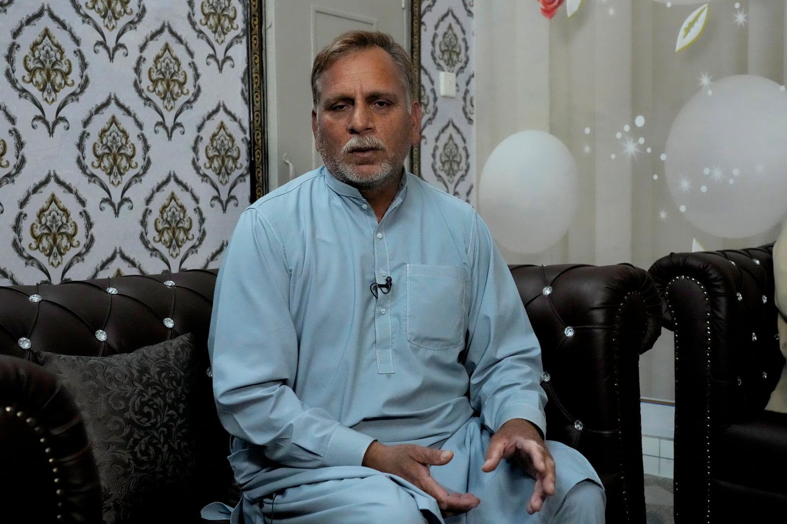 Mohammad Akram, father of Abu Bakar, one of the victims of a migrant boat that capsized in West Africa's Atlantic coastline, talks with the Associated Press at his home, in Jura village, in the Lalamusa district in Pakistan, Friday, Jan. 17, 2024. (AP Photo/K.M. Chaudary)