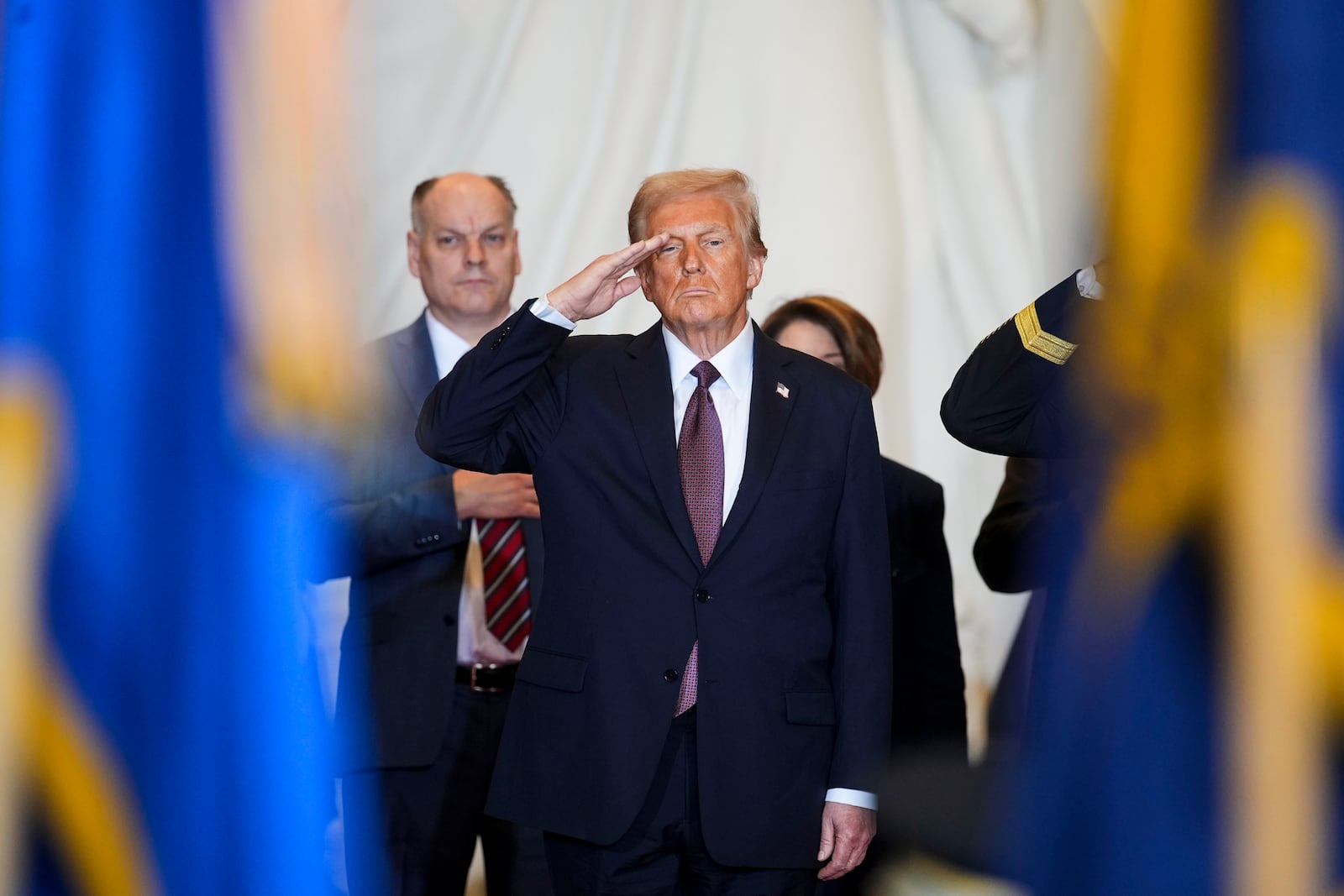 President Donald Trump salutes while on stage in Emancipation Hall at the 60th Presidential Inauguration, Monday, Jan. 20, 2025, at the U.S. Capitol in Washington. (Al Drago/Pool Photo via AP)