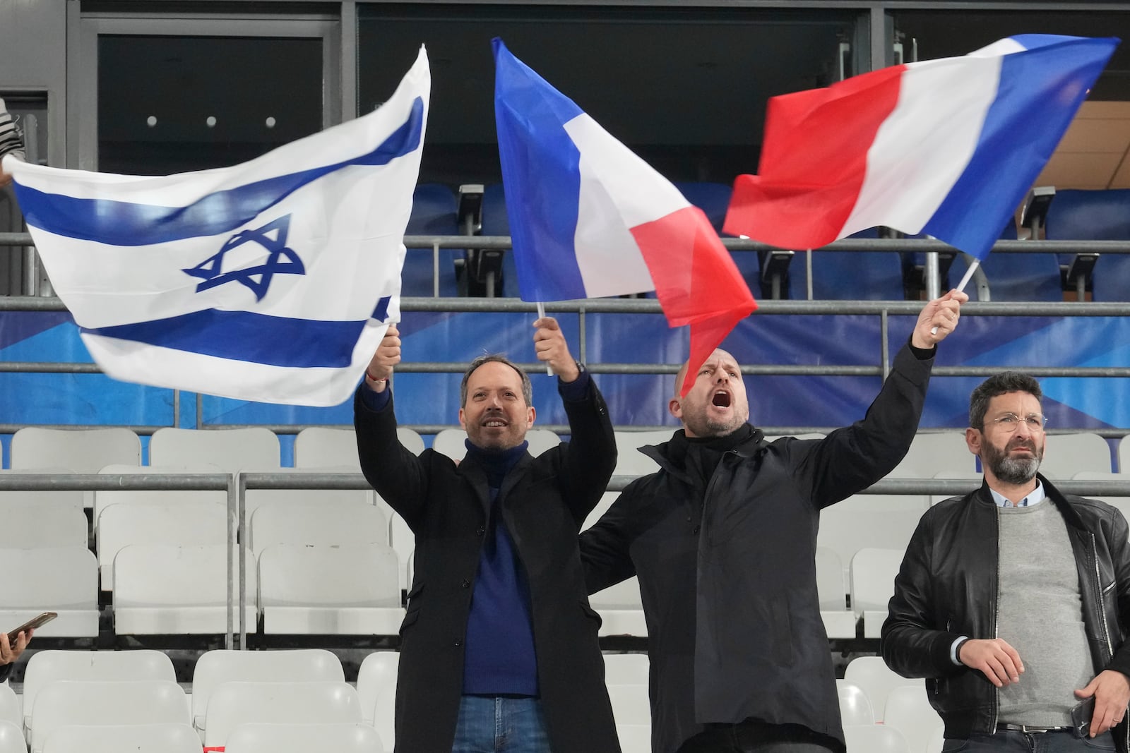 Men wave French and Israeli flags before the UEFA Nations League soccer match between France and Israel at the Stade de France stadium in Saint-Denis, outside Paris, Thursday Nov. 14, 2024. (AP Photo/Michel Euler)