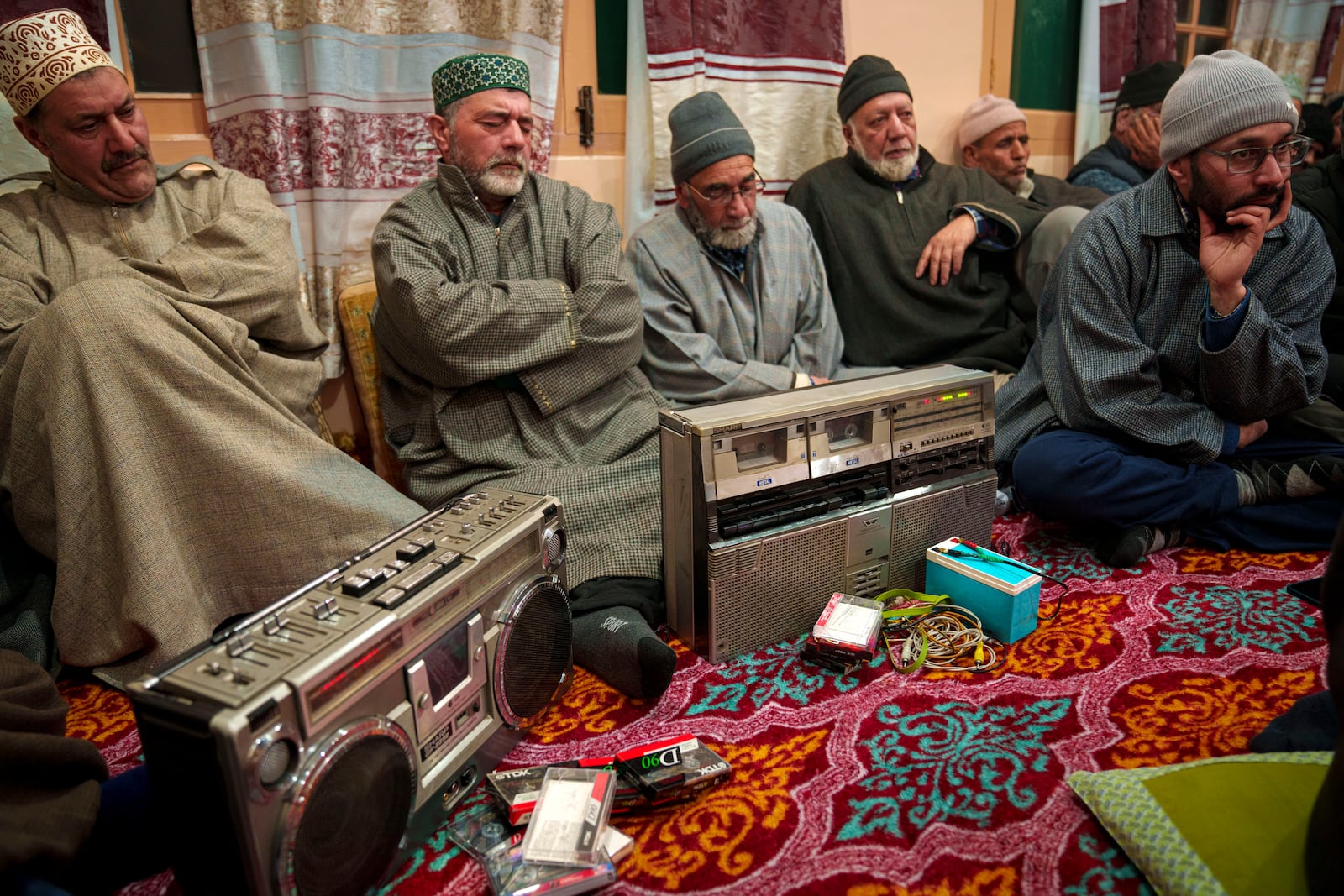 Kashmiri men listen Sufi songs on a tape recorder during a Sufi gathering in the outskirts of Srinagar, Indian controlled Kashmir, Thursday, Feb. 13, 2025. (AP Photo/Dar Yasin)