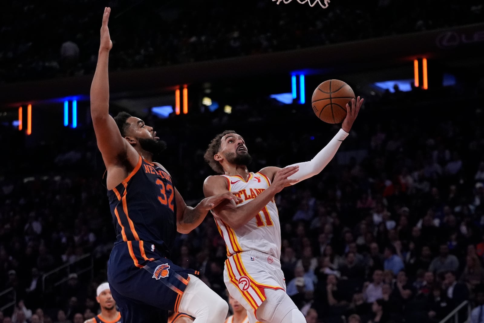 Atlanta Hawks' Trae Young (11) drives past New York Knicks' Karl-Anthony Towns (32) during an Emirates Cup NBA basketball game Wednesday, Dec. 11, 2024, in New York. (AP Photo/Frank Franklin II)