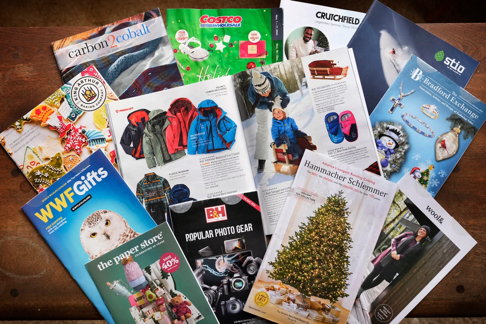 A collection of 2024 holiday catalogs are displayed Monday, Nov. 25, 2024, in Freeport, Maine. Catalog retailers, reeling from U.S. postal rate increases, have responded with pint-sized catalogs this holiday season. (AP Photo/Robert F. Bukaty)