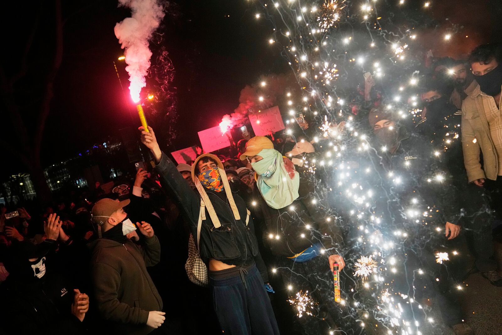 People light flares as they protest against the arrest of Istanbul's Mayor Ekrem Imamoglu, in Istanbul, Turkey, Friday, March 21, 2025. (AP Photo/Khalil Hamra)