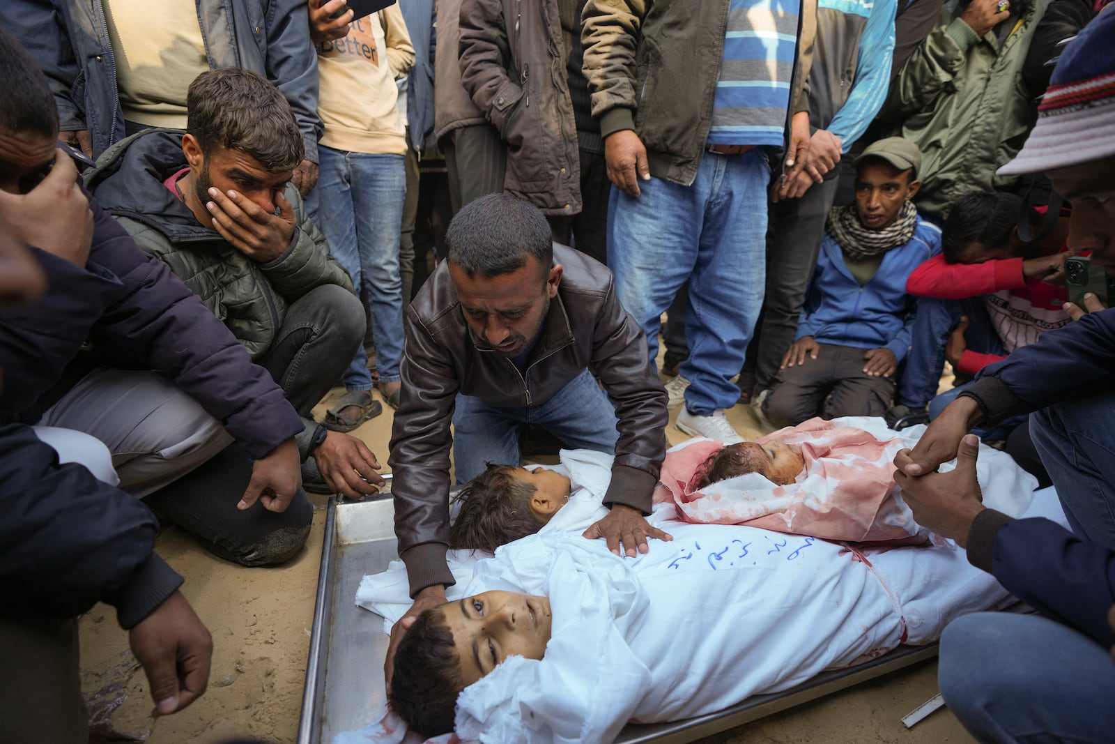 Mahmoud bin Hassan mourns over the bodies his three children before their funeral in Deir al-Balah, Gaza Strip, Thursday Nov. 21, 2024. Seven-year-old Hamza, his five-year-old brother Abdelaziz, and his four-year-old sister Laila Hassan were among 9 people killed by an Israeli strike in Khan Younis on Wednesday. Palestinian health officials say the death toll in the Gaza Strip from the 13-month-old war between Israel and Hamas has surpassed 44,000. (AP Photo/Abdel Kareem Hana)