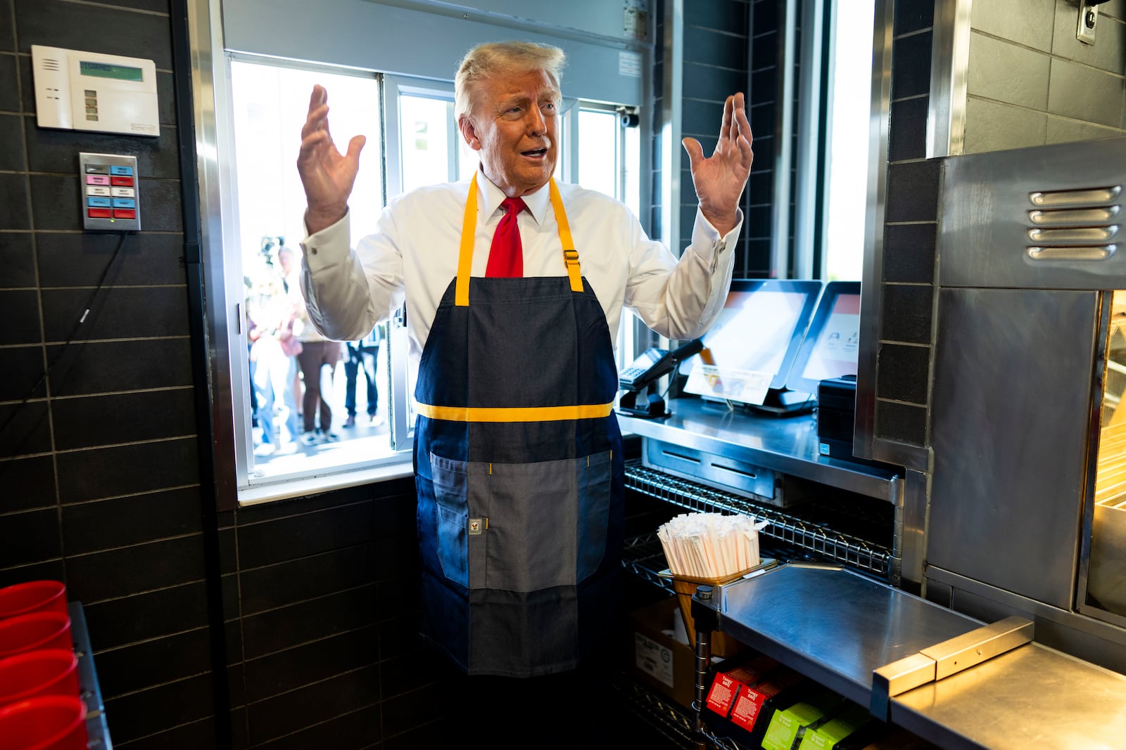 Republican presidential nominee former President Donald Trump stands at a drive-thru window during a campaign stop at a McDonald's in Feasterville-Trevose, Pa., Sunday, Oct. 20, 2024. (Doug Mills/The New York Times via AP, Pool)