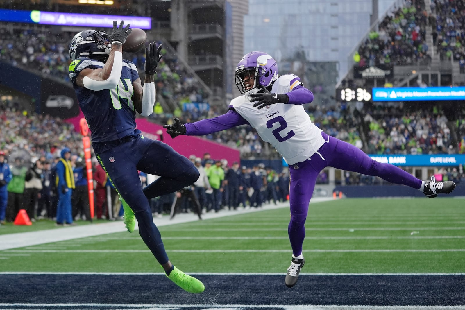 Seattle Seahawks wide receiver DK Metcalf (14) catches a 25-yard touchdown pass ahead of Minnesota Vikings cornerback Stephon Gilmore (2) during the first half of an NFL football game, Sunday, Dec. 22, 2024, in Seattle. (AP Photo/Lindsey Wasson)