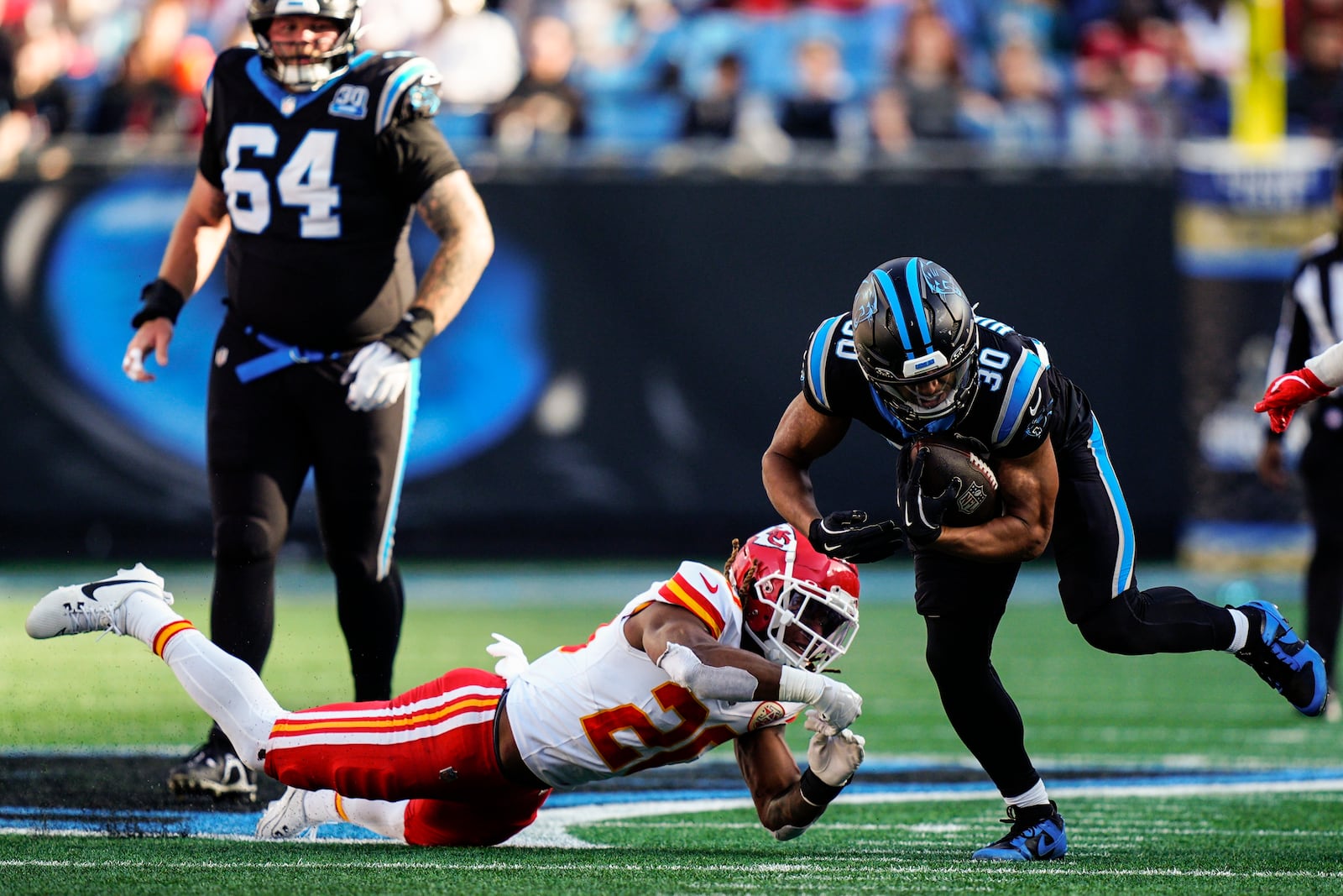 Carolina Panthers running back Chuba Hubbard (30) runs against Kansas City Chiefs safety Justin Reid (20) during the second half of an NFL football game, Sunday, Nov. 24, 2024, in Charlotte, N.C. (AP Photo/Jacob Kupferman)