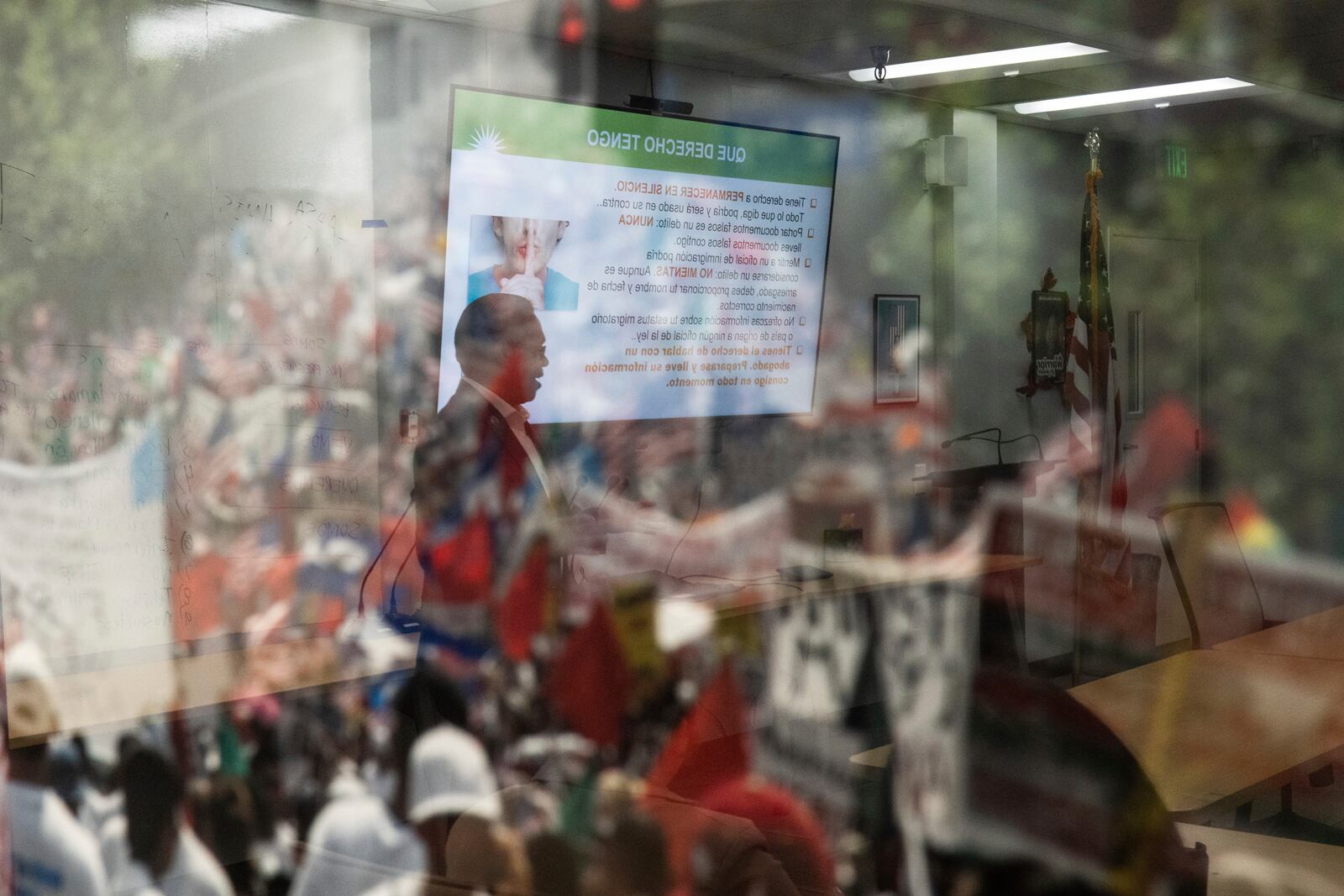 Winston Leiva, community education programs manager at the Coalition for Humane Immigrant Rights, is reflected in the glass of a photo as he gives a bilingual workshop for immigrants who want to stay in the United States, in Los Angeles, Wednesday, Dec. 4, 2024. (AP Photo/Jae C. Hong)