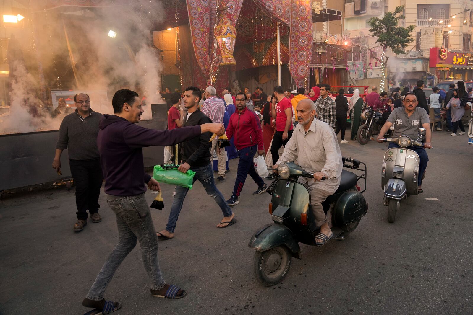 FILE - A volunteer distributes free juice ahead of Iftar, the evening meal breaking the Ramadan fast, at El-Gamaliyya district in Cairo, Egypt Friday, April 14, 2023. (AP Photo/Amr Nabil, File)