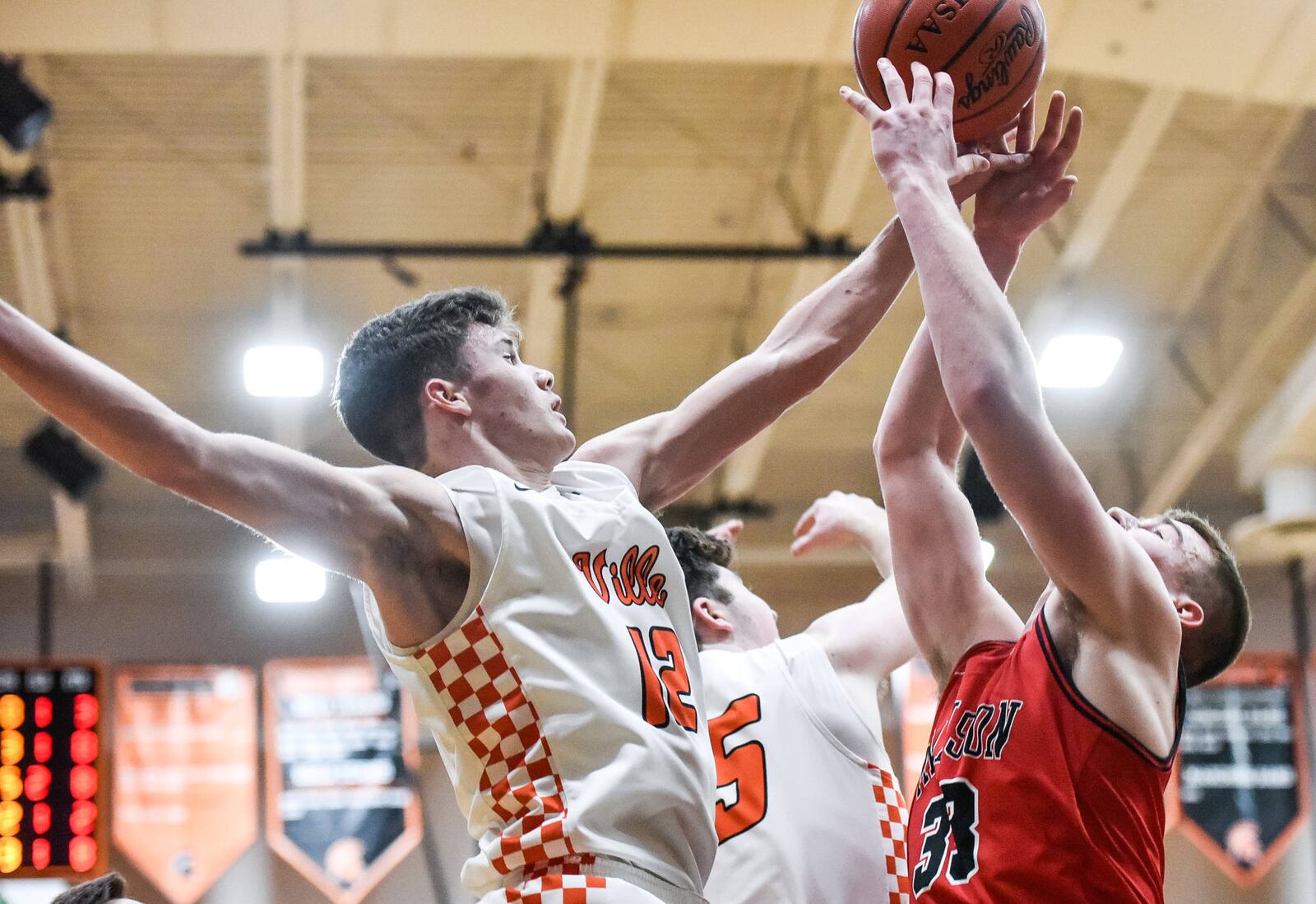 Waynesville’s John Cole (12) and Madison’s Levi McMonigle (33) battle for the ball during Friday night’s game in Waynesville. The host Spartans won 59-39. NICK GRAHAM/STAFF