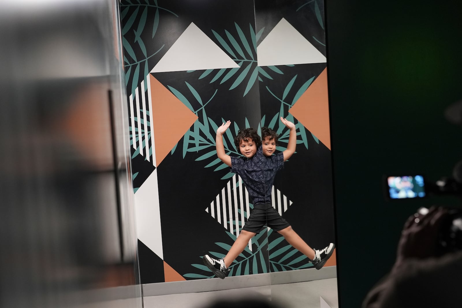 Eddven Hovvkins, 8, visiting with his family from North Carolina, poses for pictures alongside a mirror creating an optical illusion, at Paradox Museum Miami, Tuesday, Jan. 28, 2025, in Miami. (AP Photo/Rebecca Blackwell)