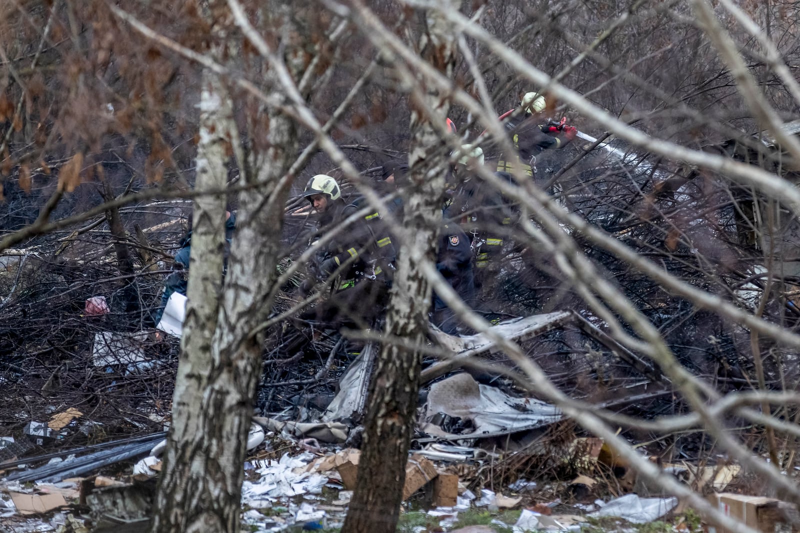 Lithuanian emergency personnel work near at the site where a DHL cargo plane crashed into a house near the Lithuanian capital Vilnius, Lithuania, Monday, Nov. 25, 2024. (AP Photo/Mindaugas Kulbis)