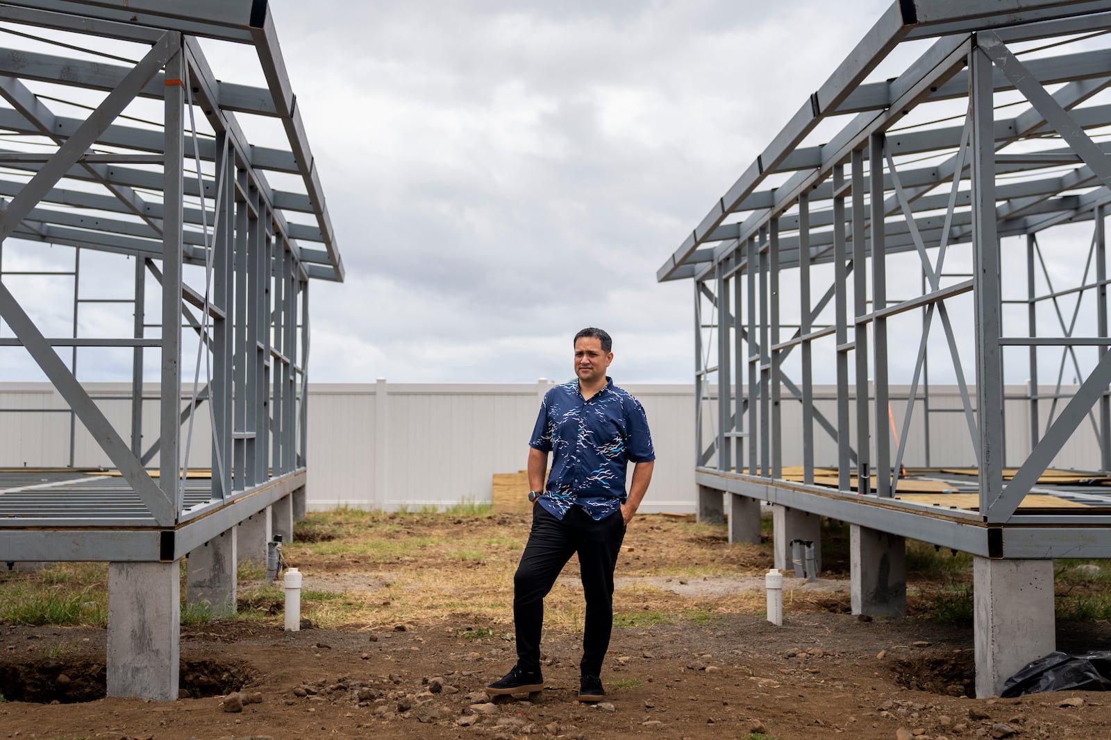 FILE - Kuhio Lewis, CEO of the Council for Native Hawaiian Advancement, stands for a portrait between two under-construction modular housing units at the Ke Ao Maluhia housing development, July 8, 2024, in Kahului, Hawaii. (AP Photo/Lindsey Wasson, File)