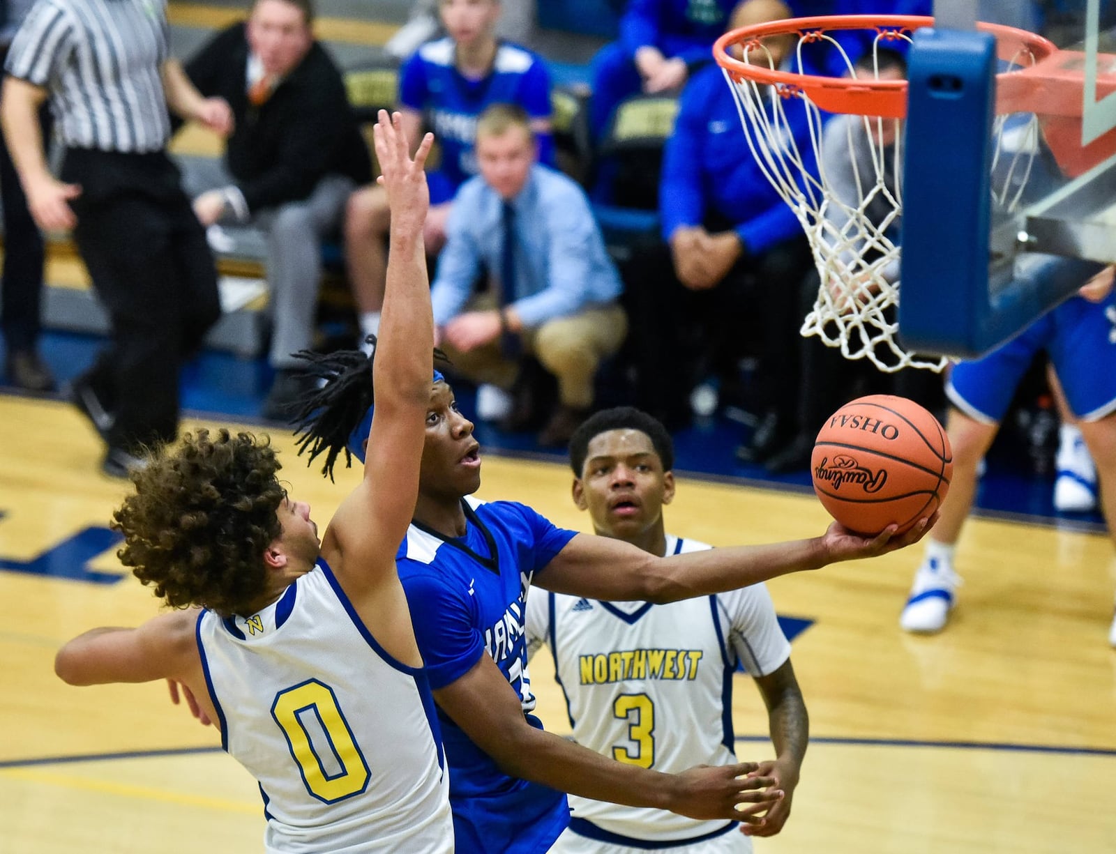 Hamilton’s D’Marco Howard puts up a shot as he is defended by Northwest’s Steven Grau (0) and Tyre McKinney (3) during their game Nov. 30 at Northwest. Hamilton won 58-52. NICK GRAHAM/STAFF