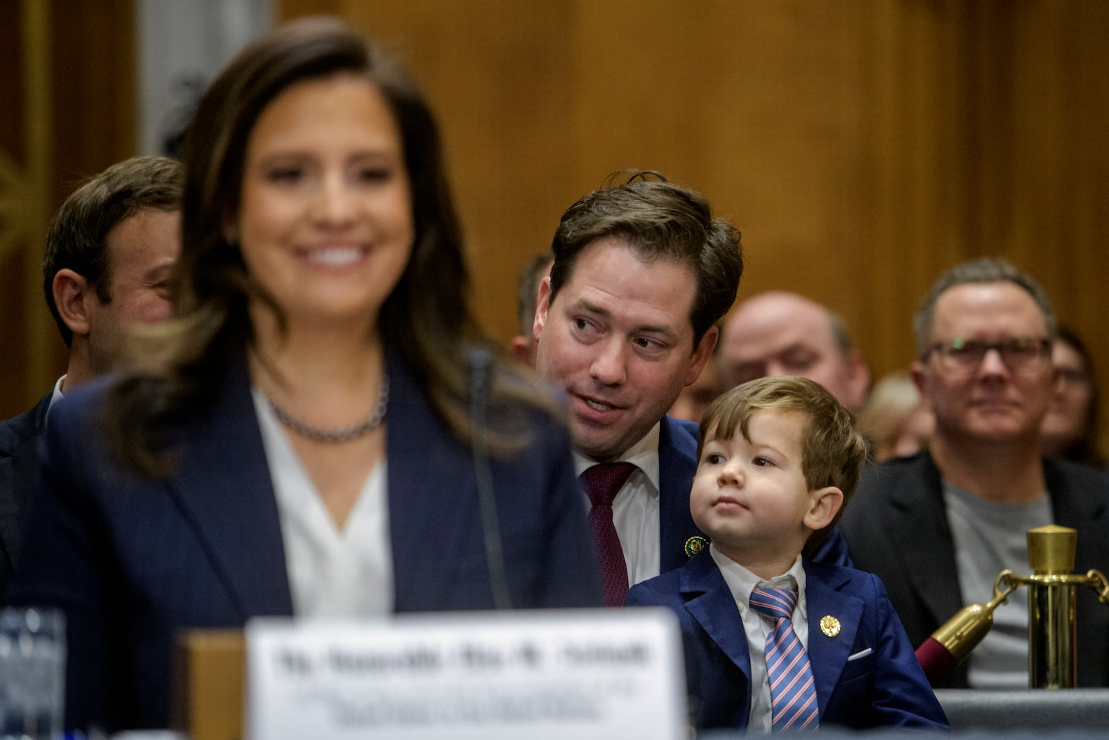 Rep. Elise Stefanik, R-N.Y., President Donald Trump's nominee to be the United Nations Ambassador, testifies as her husband Matthew Albritton Manda, center, talks with their son Samuel, 3, during a Senate Committee on Foreign Relations hearing for her pending confirmation on Capitol Hill, Tuesday, Jan. 21, 2025, in Washington. (AP Photo/Rod Lamkey, Jr.)