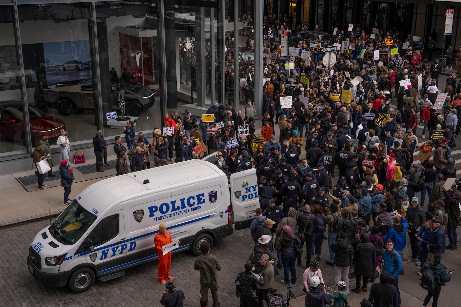 Demonstrators are arrested by NYPD officers during a protest against Elon Musk and Tesla outside of a Tesla showroom, Saturday, March 01, 2025 in New York. (AP Photo/Adam Gray)