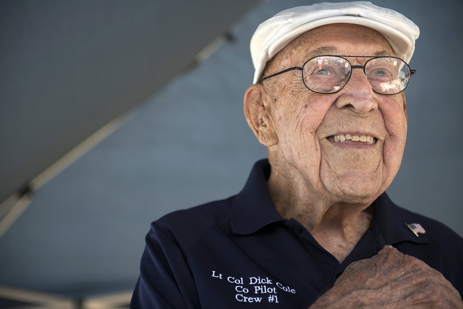 Retired Lt. Col. Richard E. Cole, copilot to Jimmy Doolittle during the Doolittle Raid, smiles as he honors the U.S. flag during the singing of the national anthem at an airshow in Burnet, Texas. Cole was honored by the community and guests as the only remaining military service member alive from the April 18, 1942, Doolittle Raid. (U.S. Air Force photo/Staff Sgt. Vernon Young Jr.)