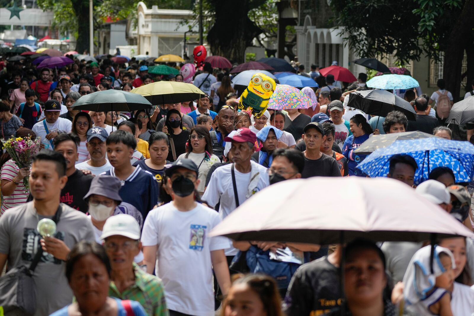 People make their way at a crowded Manila's North Cemetery, Philippines as the nation observes All Saints Day on Friday, Nov. 1, 2024. (AP Photo/Aaron Favila)