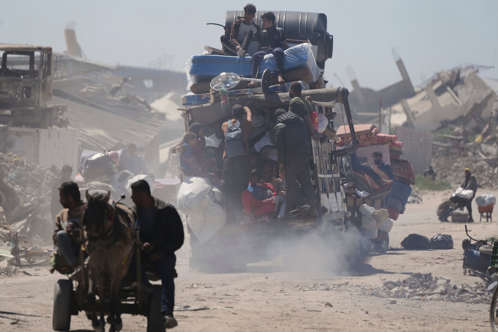 Displaced Palestinians, carrying their belongings traveling from Beit Hanoun to Jabaliya, a day after Israel's renewed offensive in the Gaza Strip, Wednesday, March 19, 2025. (AP Photo/Jehad Alshrafi)