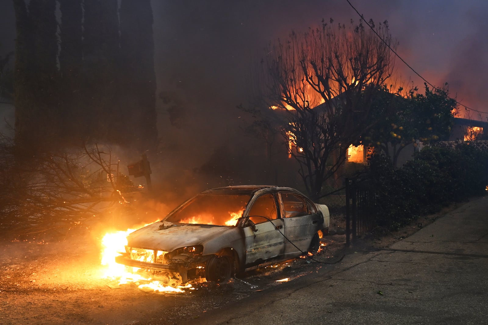 The Eaton Fire burns vehicles and structures Wednesday, Jan. 8, 2025 in Altadena, Calif. (AP Photo/Nic Coury)