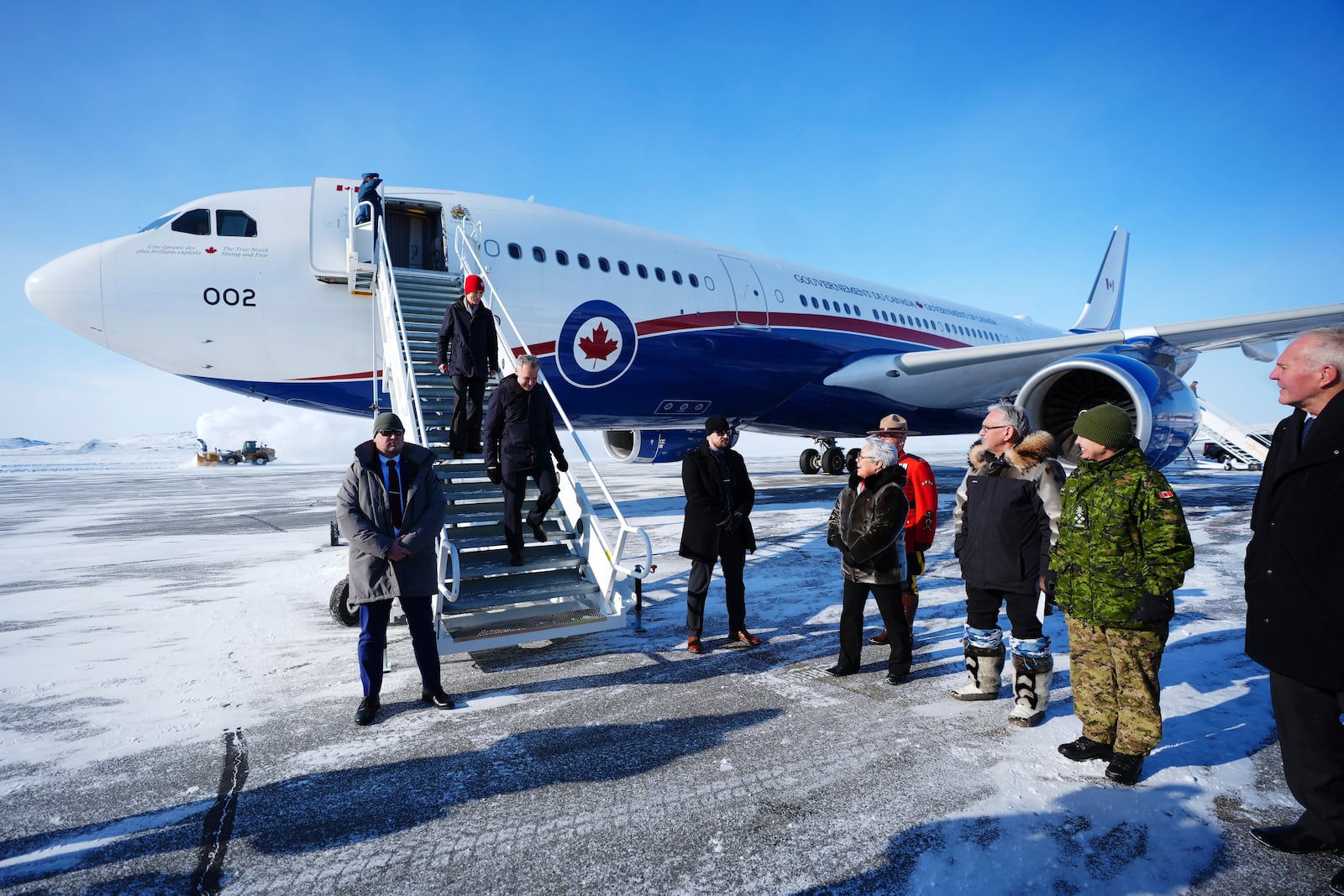 Canada Prime Minister Mark Carney and his wife Diana Fox Carney are greeted by Commissioner of Nunavut Eva Aariak, Deputy Mayor Harry Flaherty, Chief of Defense Staff Gen. Jennie Carignan and Defence Minister Bill Blair as they arrive in Iqaluit, Nunavut, on Tuesday, March 18, 2025. (Sean Kilpatrick/The Canadian Press via AP)