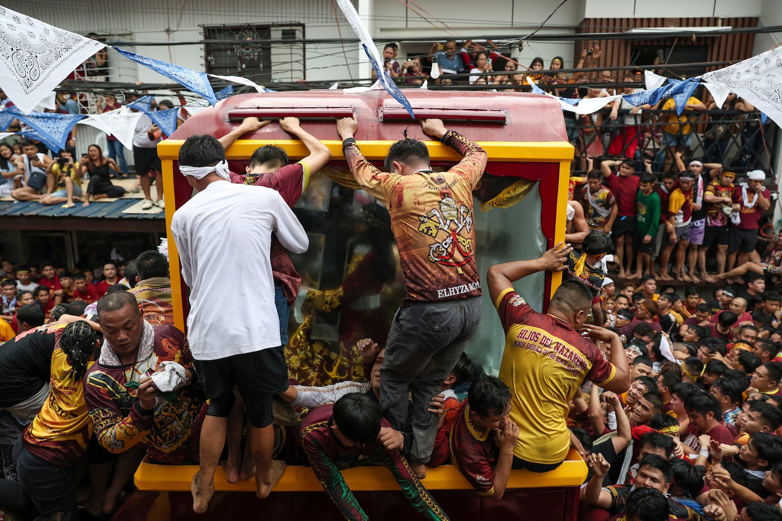 Devotees try to climb on a glass-covered carriage carrying the image of Jesus Nazareno during its annual procession in Manila, Philippines Thursday, Jan. 9, 2025. (AP Photo/Basilio Sepe)