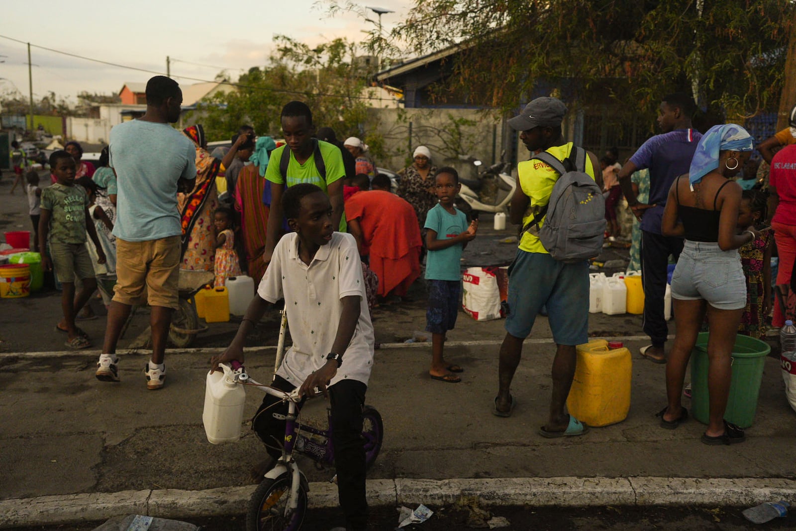 People lineup to collect water Wednesday, Dec. 18, 2024 in the French Indian Ocean island of Mayotte. (AP Photo/Adrienne Surprenant)