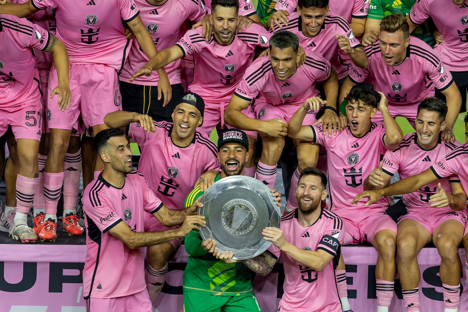 Inter Miami forward Lionel Messi, front, center right, celebrates with his teammates Sergio Busquets, front, center left, Luis Suárez, second row, left, and Drake Callender, center in green, after winning the Supporters' Shield, defeating the New England Revolution at Chase Stadium in Fort Lauderdale, Fla., Saturday, Oct. 19, 2024. (David Santiago/Miami Herald via AP)