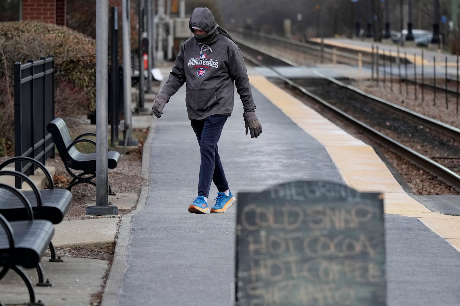 Pedestrian bundles up as he walks at a Metra train station during cold weather in Northbrook, Ill., Thursday, Dec. 12, 2024. (AP Photo/Nam Y. Huh)