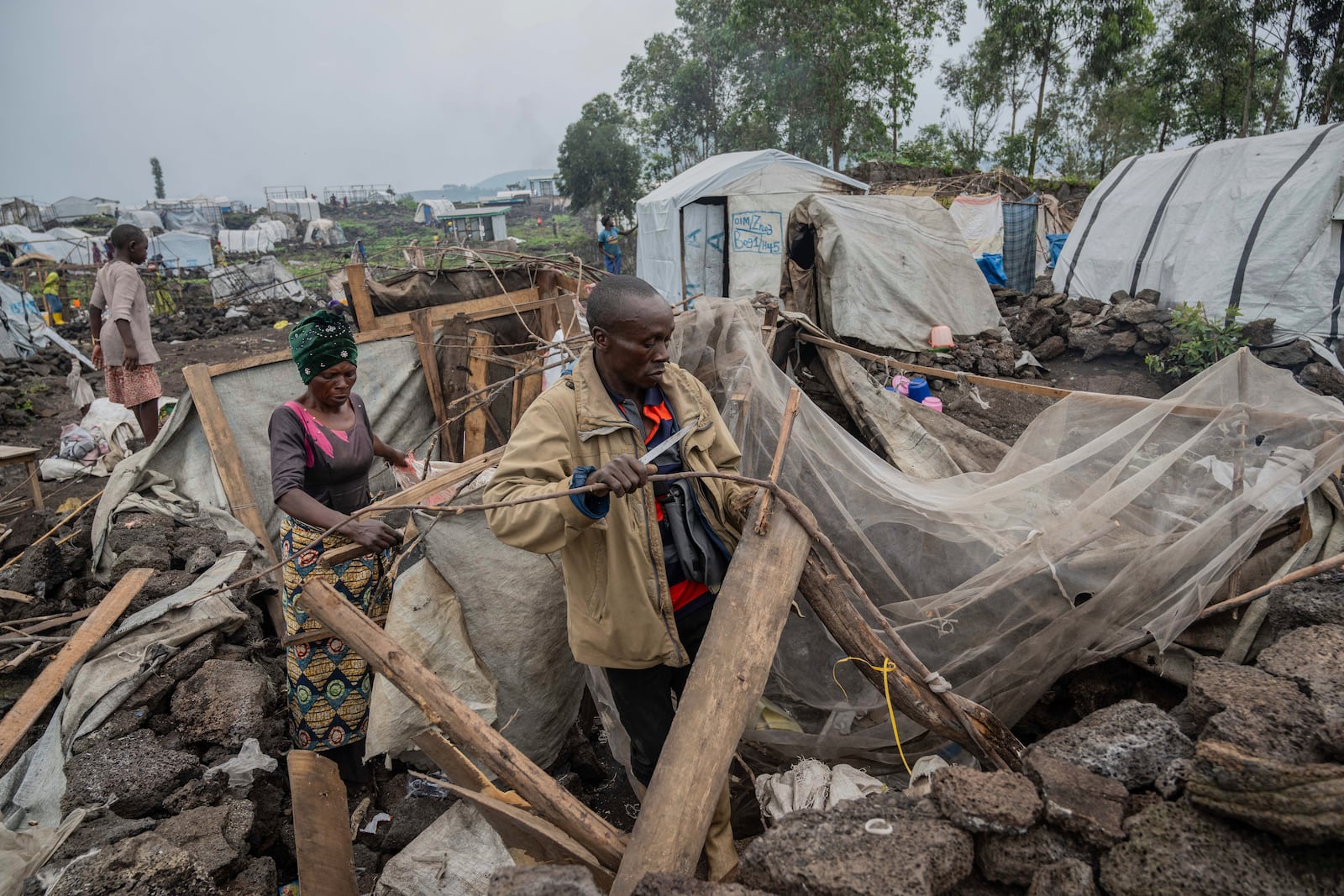 People who were displaced by the fighting between M23 rebels and government soldiers prepare to leave their camp following an instruction by M23 rebels in Goma, Democratic Republic of the Congo, Tuesday, Feb. 11, 2025. (AP Photo/Moses Sawasawa)