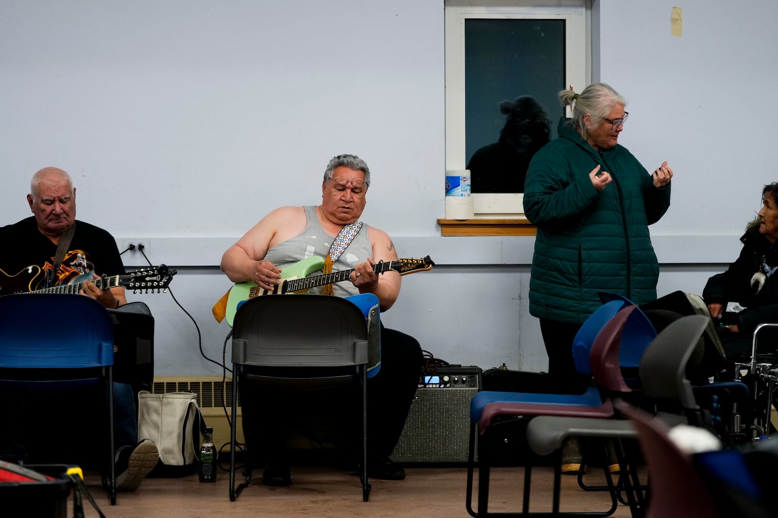 George Kaleak, center in grey, whaling captain and deputy advisor to the North Slope Borough mayor, plays guitar during a "singspiration" community event to honor his late mother at the village community center in Kaktovik, Alaska, Monday, Oct. 14, 2024. (AP Photo/Lindsey Wasson)