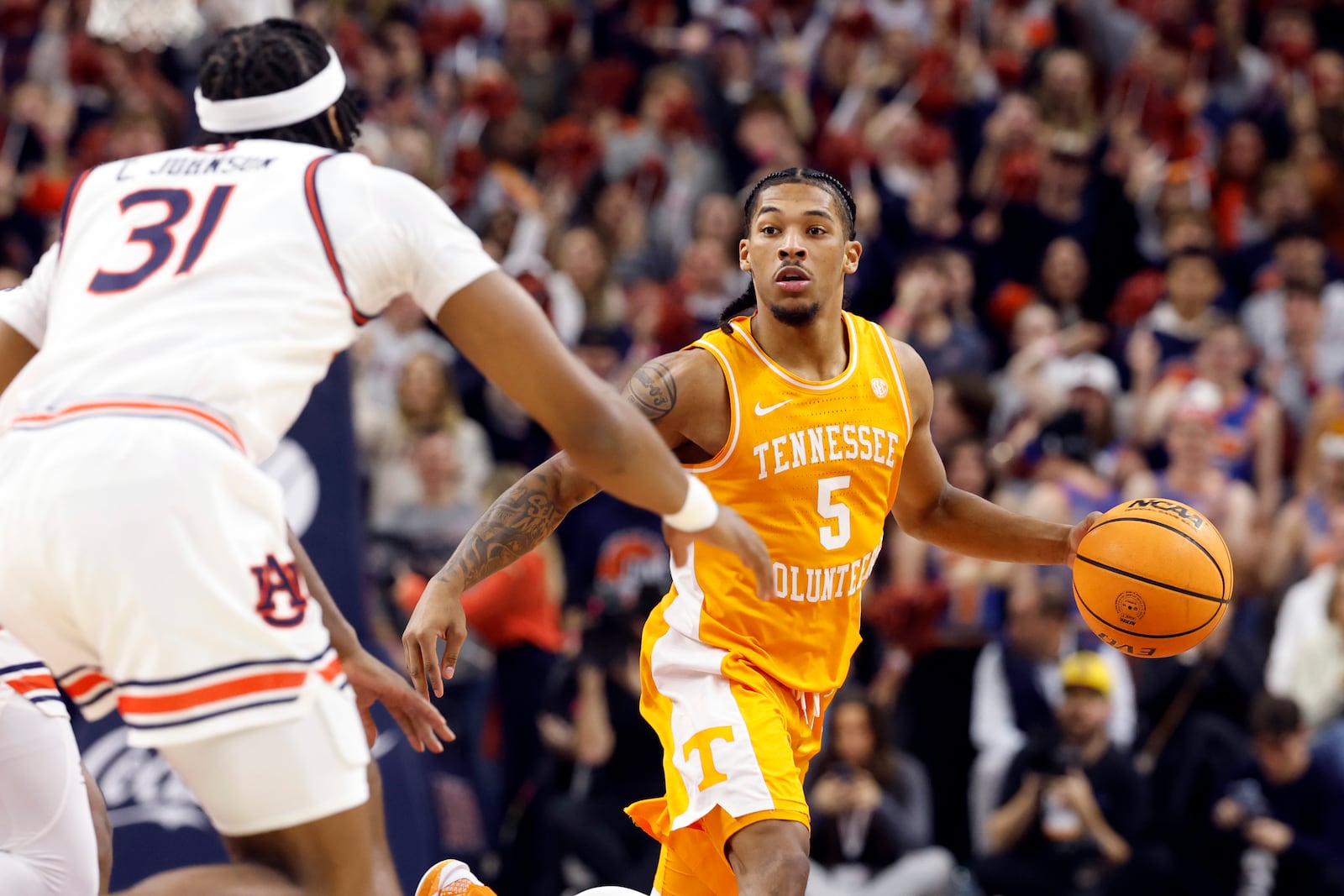 Tennessee guard Zakai Zeigler (5) dribbles around Auburn forward Chaney Johnson (31) during the first half of an NCAA college basketball game, Saturday, Jan. 25, 2025, in Auburn. (AP Photo/Butch Dill)