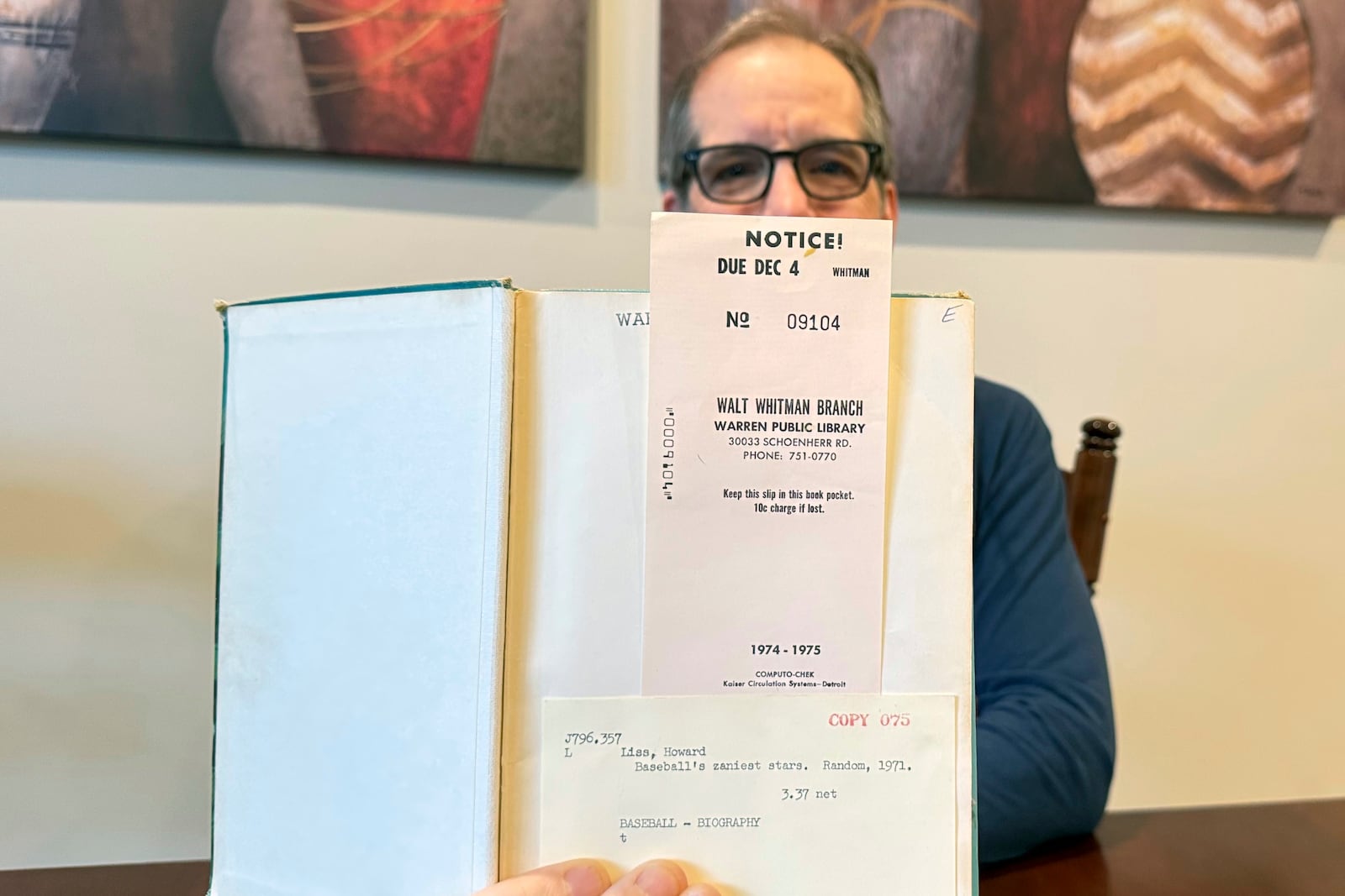 Chuck Hildebrandt of Chicago holds the book "Baseball's Zaniest Stars" on Dec. 10, 2024, which was due back at the Warren, Mich., library on Dec. 4, 1974. (Terrie Wendricks via AP)