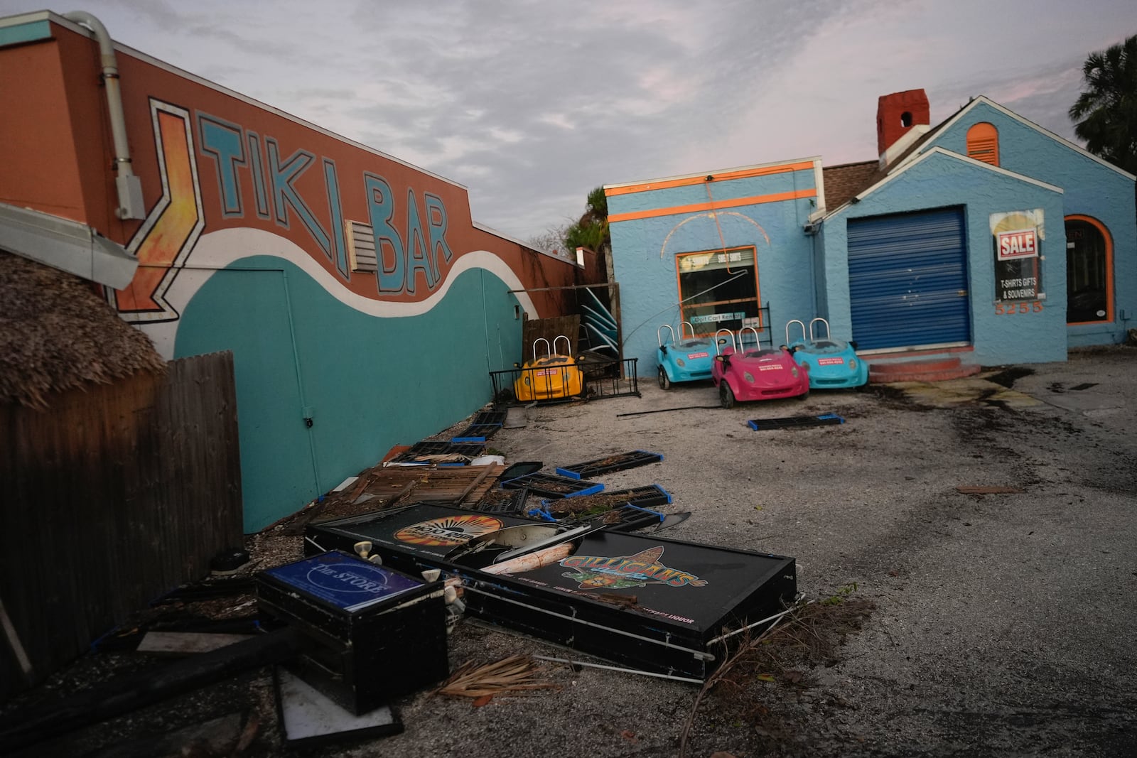 A broken sign and other debris lie alongside Gilligan's Island Bar & Grill after the passage of Hurricane Milton, in Siesta Key, Fla., Thursday, Oct. 10, 2024. (AP Photo/Rebecca Blackwell)