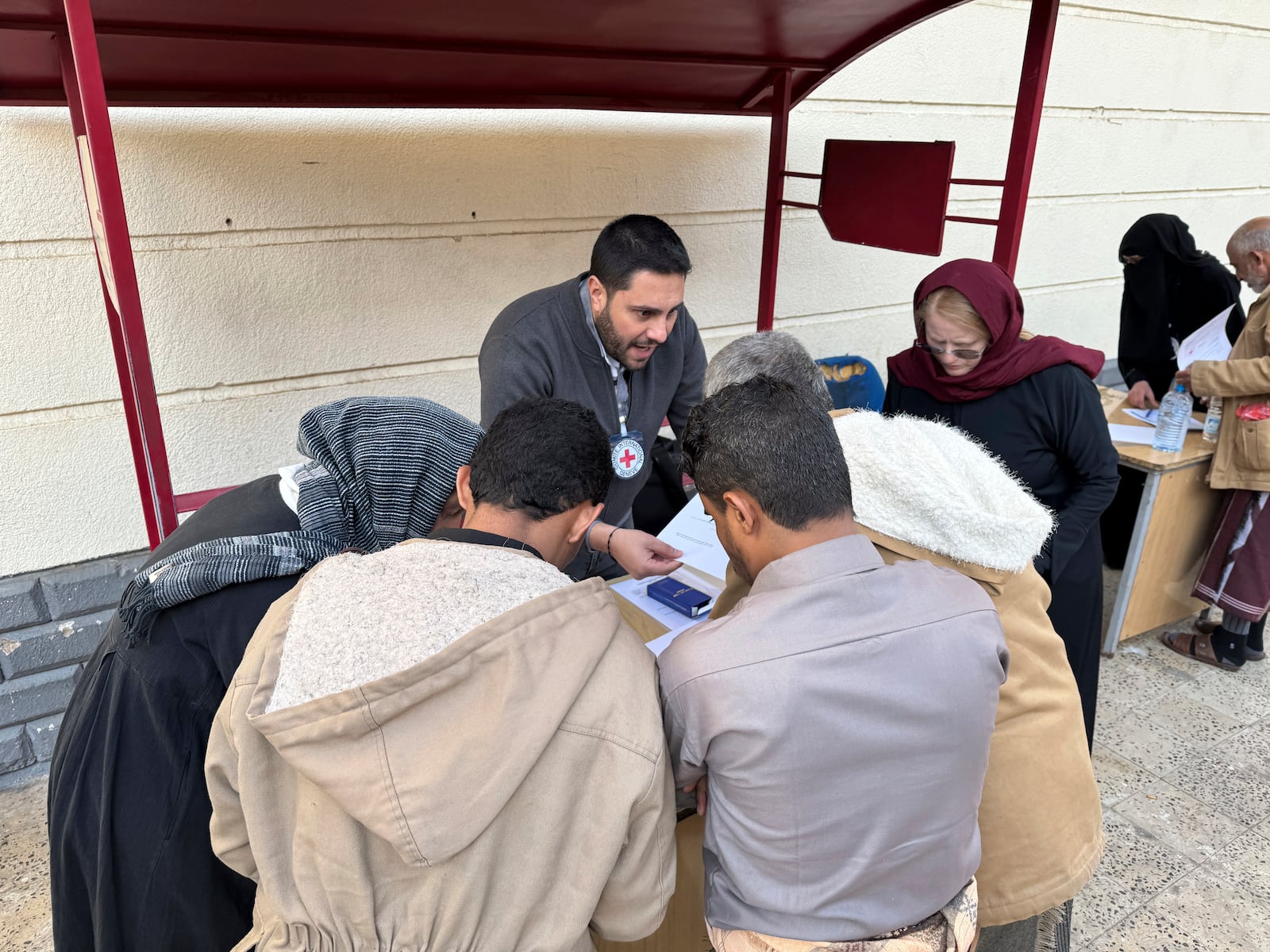 This photo released by the International Committee of the Red Cross shows its officials helping prisoners prepare to be freed by Yemen's Houthi rebels, in Sanaa, Yemen, Saturday, Jan. 25, 2025. (International Committee of the Red Cross via AP)