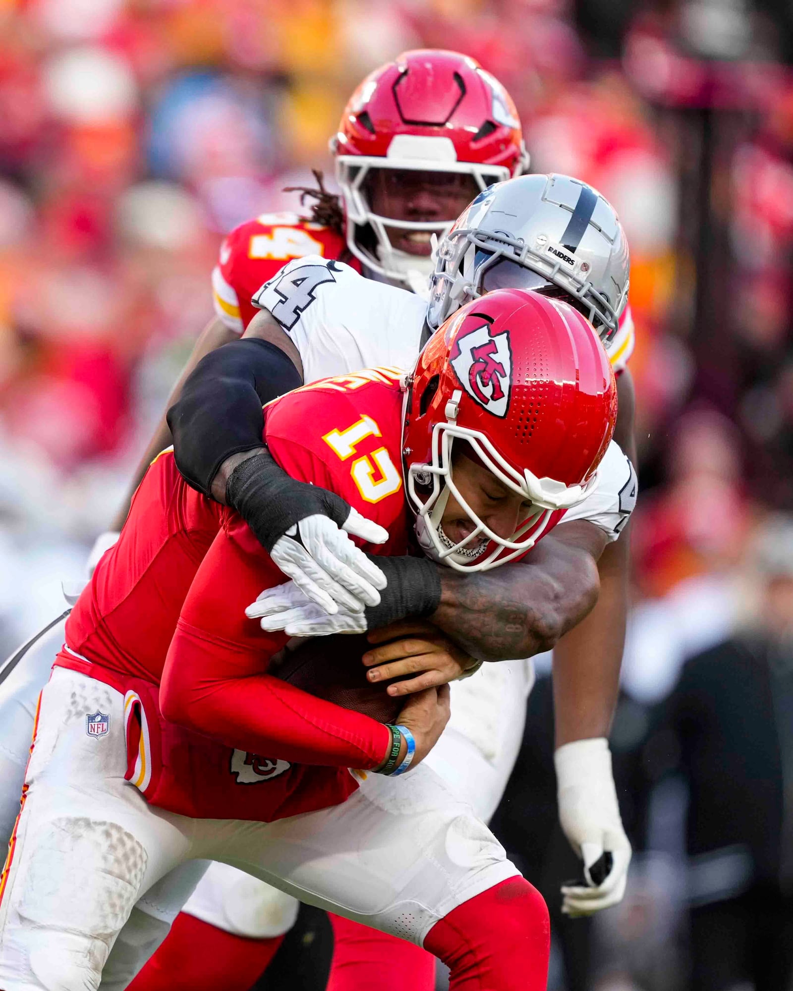 Kansas City Chiefs quarterback Patrick Mahomes (15) is sacked by Las Vegas Raiders defensive end K'Lavon Chaisson (44) during the first half of an NFL football game in Kansas City, Mo., Friday, Nov. 29, 2024. (AP Photo/Ed Zurga)