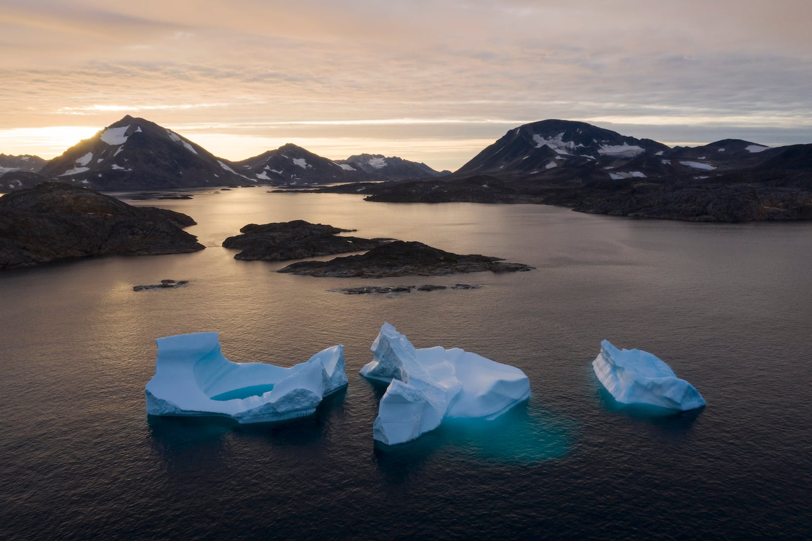 FILE - Large Icebergs float away as the sun rises near Kulusuk, Greenland, Aug. 16, 2019. (AP Photo/Felipe Dana, File)