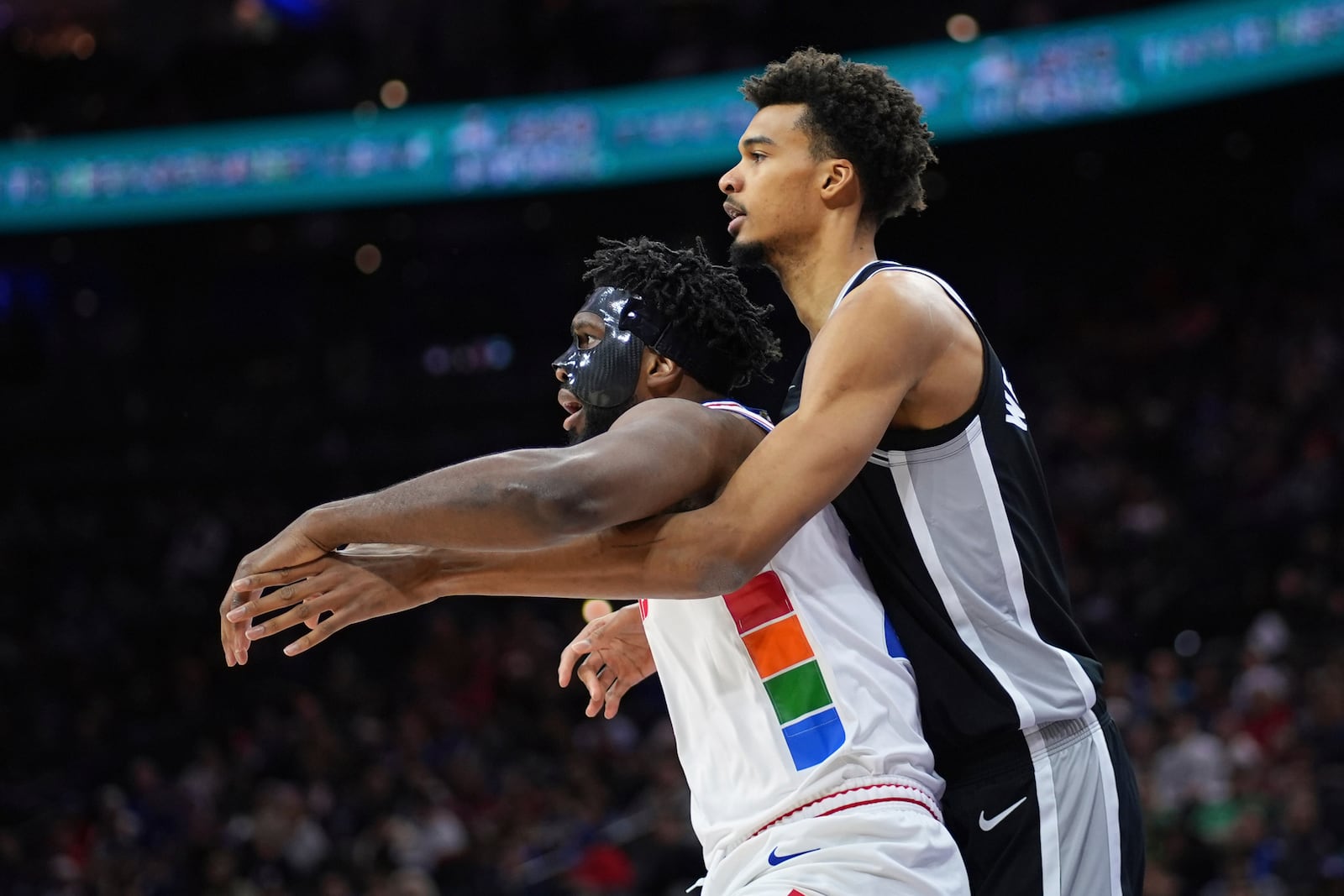 Philadelphia 76ers' Joel Embiid, left, and San Antonio Spurs' Victor Wembanyama battle for postinon during the first half of an NBA basketball game, Monday, Dec. 23, 2024, in Philadelphia. (AP Photo/Matt Slocum)