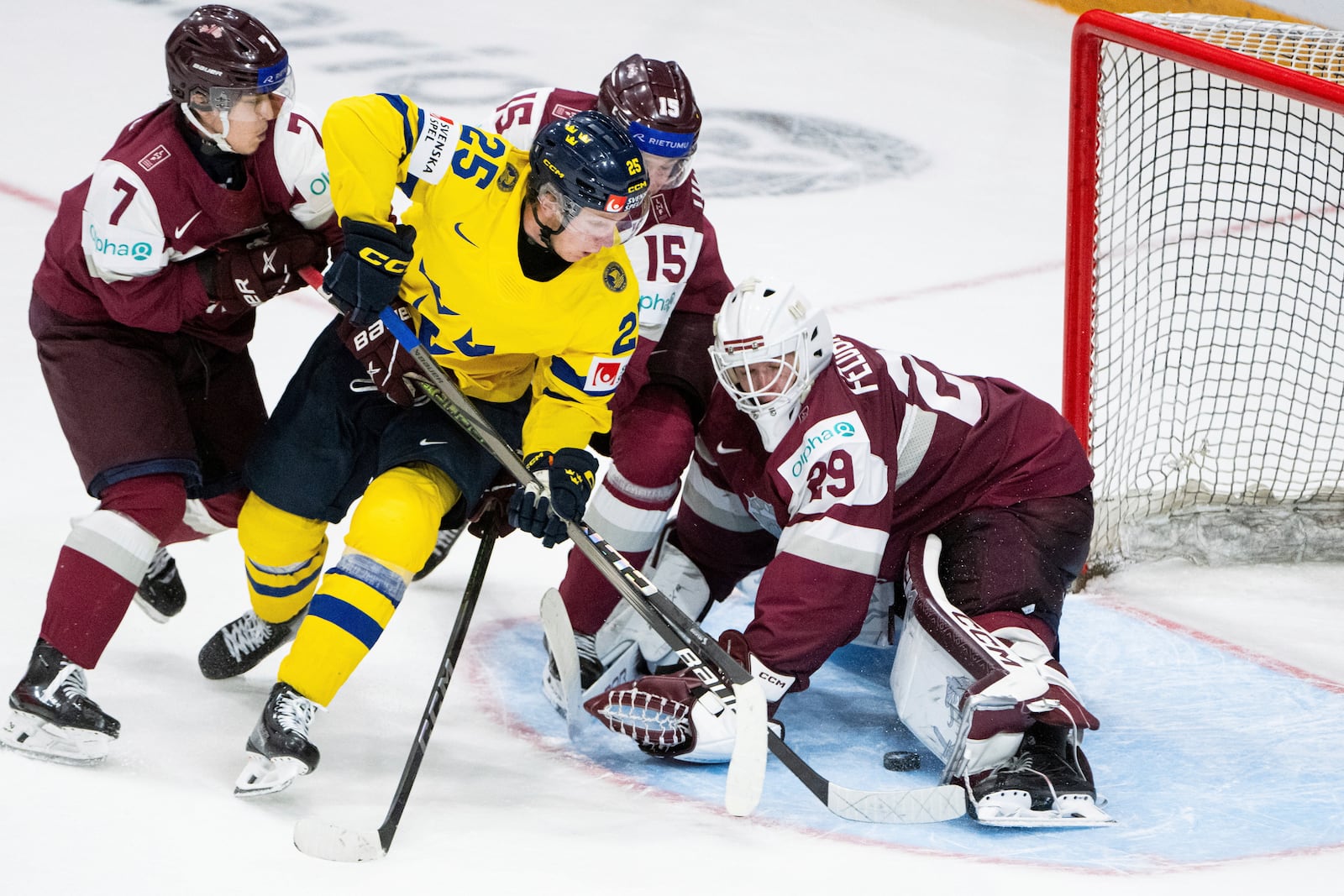 Team Sweden forward Otto Stenberg (25) tries to score on Team Latvia goaltender Linards Feldbergs (29) as Latvia forward Davis Livsics (7) and defenseman Darels Uljanskis (15) defend during the third period of an IIHF World Junior Hockey Championship quarterfinal match in Ottawa, Ontario Thursday, Jan. 2, 2025. (Spencer Colby/The Canadian Press via AP)