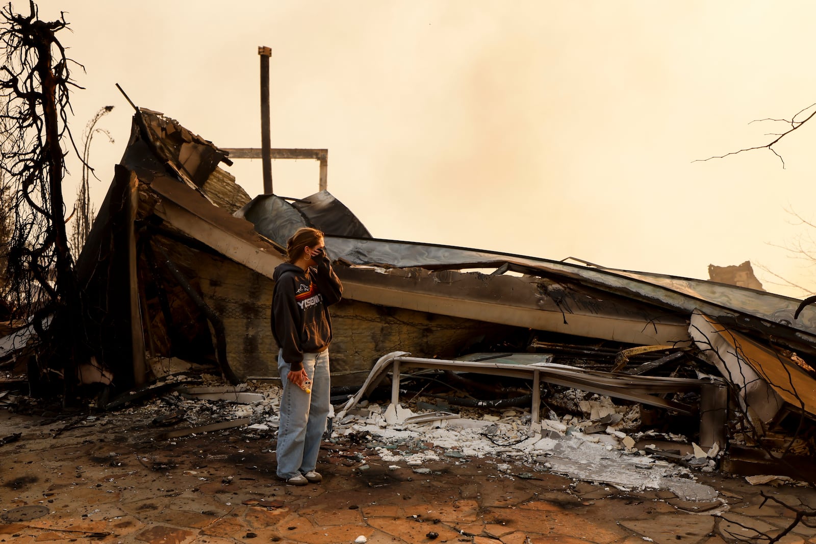 Fallon Prockiw-Kline gets emotional in front of her home which was damaged by the Palisades Fire, Wednesday, Jan. 8, 2025, in Malibu, Calif. (AP Photo/Etienne Laurent)