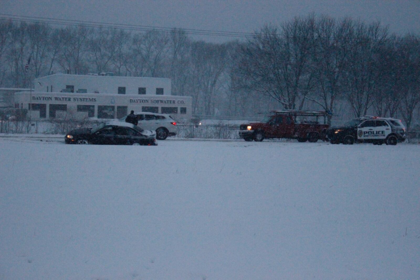 A West Carrollton police officer assists a driver who slid off the roadway on eastbound I-75 near mile marker 45 in West Carrollton.