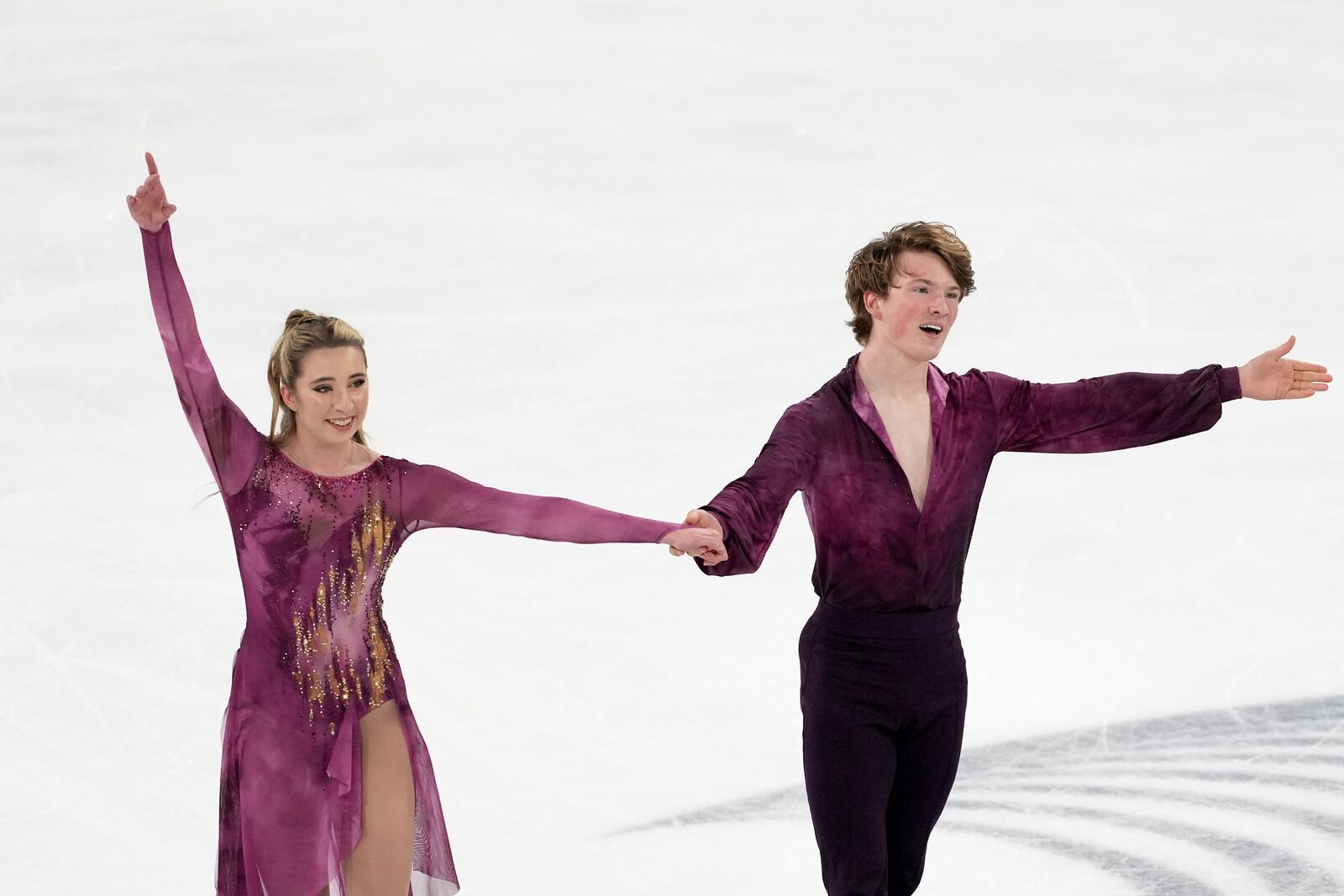 Emily Bratti and Ian Somerville, of the United States, gesture to fans after competing in the ice dance's free dance segment at the ISU Grand Prix of Figure Skating, Saturday, Nov. 2, 2024, in Angers, France. (AP Photo/Aurelien Morissard)