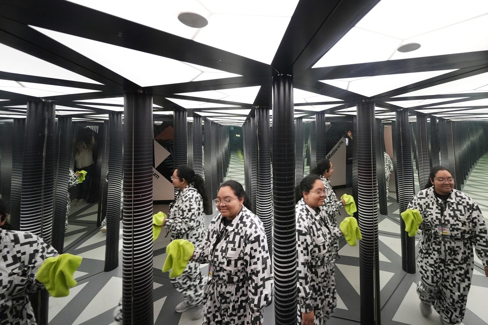 Paradox Museum Miami guide Maria Wong walks through a mirror maze as she checks for areas that need cleaning, Tuesday, Jan. 28, 2025, in Miami. (AP Photo/Rebecca Blackwell)