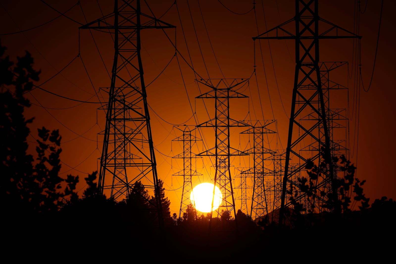 FILE - The sun sets behind high tension power lines on Sept. 23, 2024, in the Porter Ranch section of Los Angeles. (AP Photo/Mark J. Terrill, File)