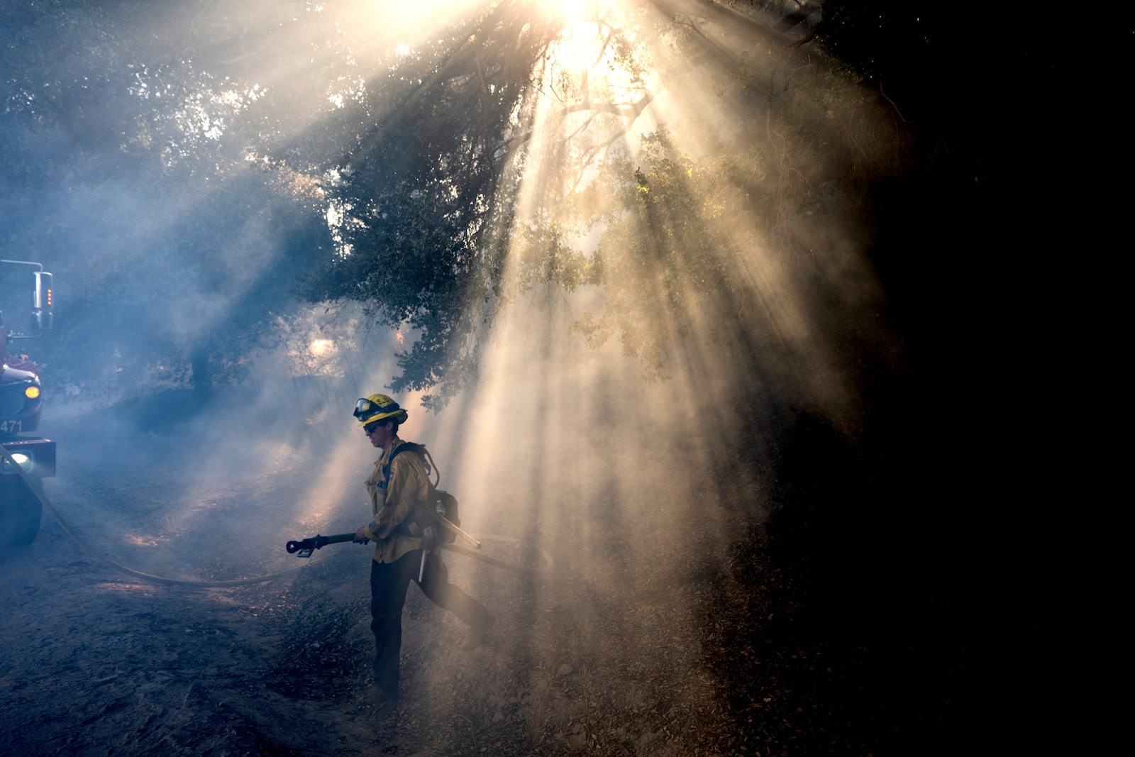 A firefighter walks through smoke while battling the Mountain Fire on Thursday, Nov. 7, 2024, in Santa Paula, Calif. (AP Photo/Noah Berger)