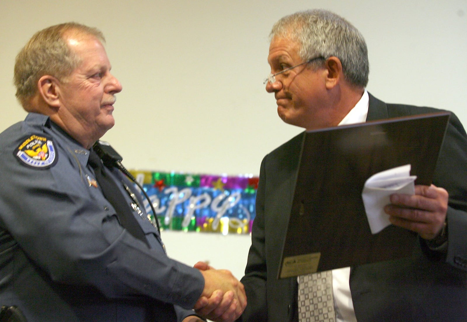 Middletown Police Chief Greg Schwarber, right, congratulates officer Mike Davis on his retirement from the department during a ceremony at the Middletown City Building in 2011.