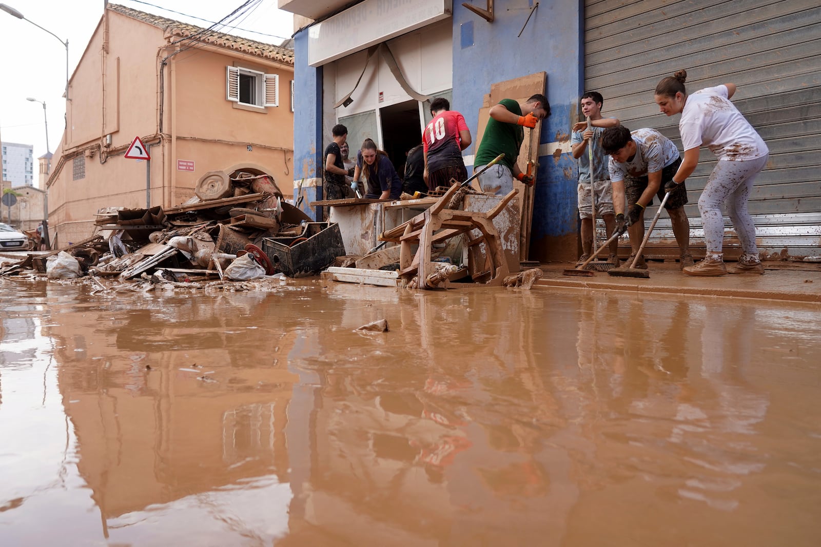 Residents clean their house affected by floods in Valencia, Spain, Thursday, Oct. 31, 2024. (AP Photo/Alberto Saiz)